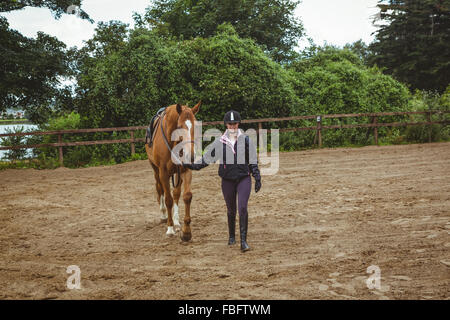 Cavalier femelle menant son cheval Banque D'Images