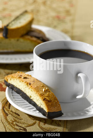 Biscotti sur une soucoupe avec une tasse de café Banque D'Images