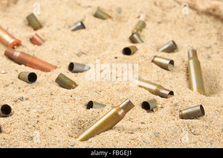 Les douilles de cartouche sur le sable. Banque D'Images