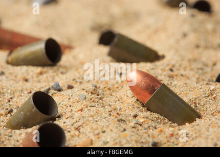 Les douilles de cartouche sur le sable. Banque D'Images