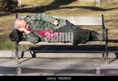 Sofia, Bulgarie - le 14 janvier 2016 : Sans-abri est en train de dormir sur un banc de Sofia. La Bulgarie est le pays le plus pauvre de l'UE. Banque D'Images