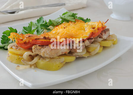 Pommes de terre au four avec oignons, tomates et à la viande avec du fromage Banque D'Images