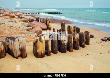 Plage déserte avec colonne en bois ancien Banque D'Images