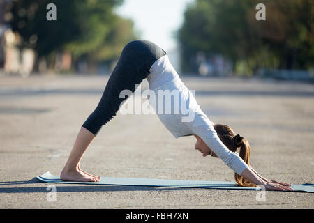 Le Yoga dans la ville : belle young woman wearing sportswear travaillant dans la rue sur journée d'été, faisant face vers le bas Banque D'Images
