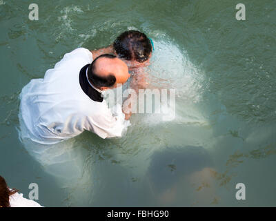 Christian prêtre baptisant un homme à Yardenit site baptismal dans Jourdain Banque D'Images