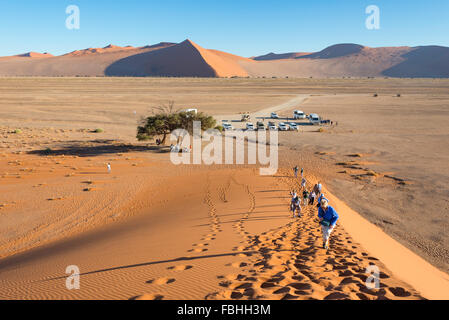 Escalade les touristes, des dunes de sable Sossusvlei, Désert du Namib, le parc de Namib Naukluft, Région Hardap, République de Namibie Banque D'Images