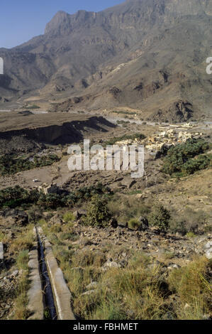 Wadi Bani Kharus, Oman. Canal d'irrigation (Falaj) Transporte l'eau jusqu'au village et date Palms ci-dessous. Banque D'Images