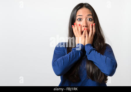 Femme dans la terreur et la panique réagir maintenant ses mains sur ses joues comme elle hurle , blanc sur la partie supérieure du corps Banque D'Images