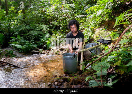 Un agriculteur qui prend de l'eau dans un ruisseau dans une forêt située à la limite ouest de l'écosystème de Batang Toru dans le centre de Tapanuli, au nord de Sumatra, en Indonésie. Banque D'Images