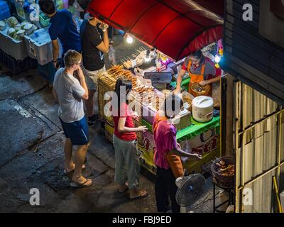 Bangkok, Bangkok, Thaïlande. 17 Jan, 2016. Les gens des viandes grillées et d'un vendeur de saucisses sur Sukhumvit Soi 38, l'un des plus célèbres domaines de l'alimentation de rue à Bangkok. Les chariots et les petits restaurants le long de la rue ont été populaires auprès des touristes et les thaïlandais pour plus de 40 ans. La famille qui est propriétaire du terrain le long de la di a récemment décidé de vendre à un promoteur de condominiums et de ne pas renouveler les baux des propriétaires de restaurant. Plus de 40 restaurants et de chariots devront fermer. La plupart des restaurants sur la rue fermée durant l'été 2015. Les autres restaurants sont supp Banque D'Images