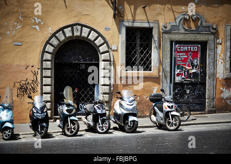 Scooter en face d'un mur de la maison, parking au bord de la route, Italie Banque D'Images