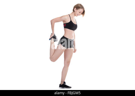 Jeune belle femme slim l'échauffement avant et après l'entraînement, s'étirant ses jambes, pleine longueur studio isolé Banque D'Images