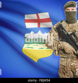 Soldat avec mitraillette dans les mains et les provinces du drapeau sur la série d'arrière-plan - Alberta Banque D'Images