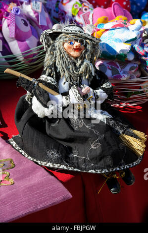 Une petite sorcière doll wearing glasses holding a broom à vendre, Dubrovnik, Croatie. Banque D'Images