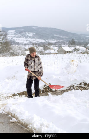 Concept de nettoyage d'hiver et - homme de pelleter de la neige à partir de l'entrée Banque D'Images