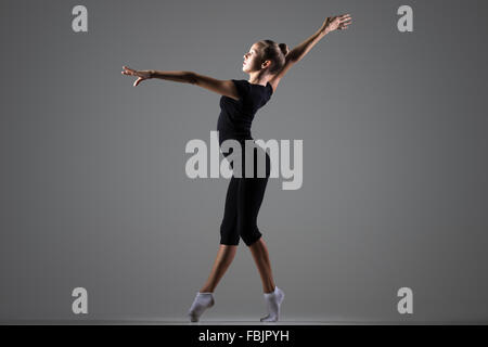 Cool belle jeune femme athlète gymnaste monter dans les vêtements de sport, de la danse sur la pointe des pieds, faisant de l'exercice de gymnastique artistique Banque D'Images