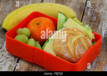 Lunch Box contenant du fromage sandwich, mandarine, banane et raisins Banque D'Images