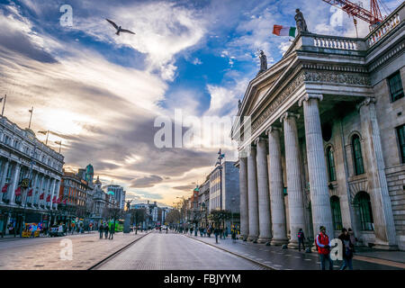 Un oiseau voiles sur le GPO historique immeuble sur Dublin O'Connell Street, tandis que l'Irish National drapeau flotte sur le dessus. Banque D'Images