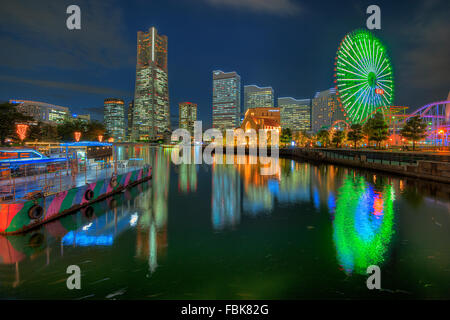 La réflexion de Yokohama Landmark Tower et les immeubles de bureaux modernes sur l'eau au cours de la fin de soirée Banque D'Images