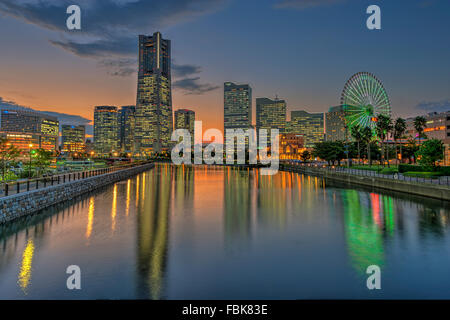 La réflexion de Yokohama Landmark Tower et les immeubles de bureaux modernes sur l'eau au crépuscule Banque D'Images