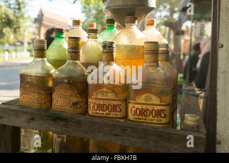 L'essence dans des bouteilles de gin ancienne sur le côté de la route de Siem Reap, Cambodge. Banque D'Images