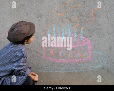 Dessin garçon gâteau d'anniversaire sur le mur avec de la craie Banque D'Images