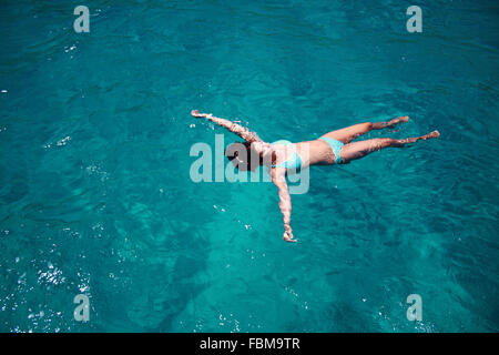 Vue aérienne d'une femme flottant dans la mer, Porto Cervo, Olbia-Tempio, Sardaigne, Italie Banque D'Images