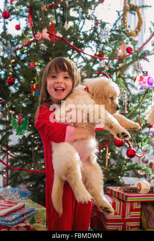 Girl hugging chiot golden retriever dog à Noël Banque D'Images