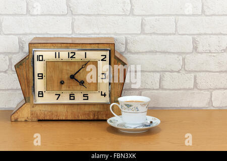 Vintage art deco pendule en bois avec de vieux mur en brique blanche et fond effet chine tasse et rempli de plateau Banque D'Images