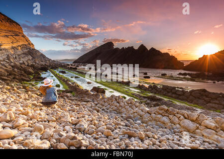 Une jeune femme de race blanche à El Madero beach par le crépuscule. Liencres, Cantabrie, Espagne. Banque D'Images