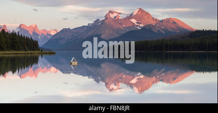 Le lac Maligne, l'un des joyau des Rocheuses canadiennes, par le coucher du soleil. Le Parc National Jasper, Alberta, Canada. Banque D'Images