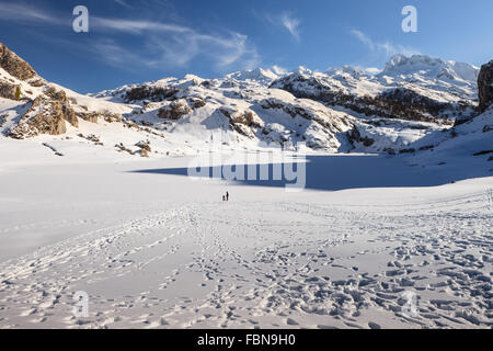 Deux personnes de race blanche par lac Ercina congelé, Covadonga, parc national des Picos de Europa, Asturias, Espagne. Banque D'Images