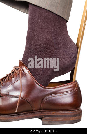 Homme met sur brown shoe avec chausse-pied isolé sur fond blanc Banque D'Images