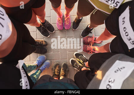 Vue de dessus de pieds de gens debout en cercle. Au cours d'un échange permanent de coureurs avec leurs pieds ensemble. Banque D'Images