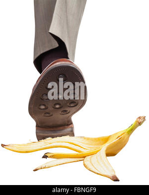 Dans la bonne jambe mâle brown shoe marcher sur peau de banane isolé sur fond blanc Banque D'Images