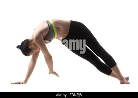 Portrait de jeune femme brune belle sportive en soutien-gorge de sport et des pantalons de travail, faire des exercices de Pilates Banque D'Images