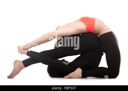 Couple sportive sur fond blanc faire acroyoga, ou de remise en forme pratique pilates, yoga en couple avec son partenaire, de chameau (ustrasana) Banque D'Images