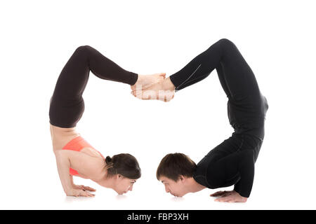 Profil de deux sportifs faisant backbend handstand, yogi couple standing in yoga asanas ganda bherundasana équilibre chin Banque D'Images