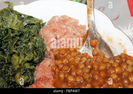 Plat d'épinards cuits durs, salami et lentilles Banque D'Images