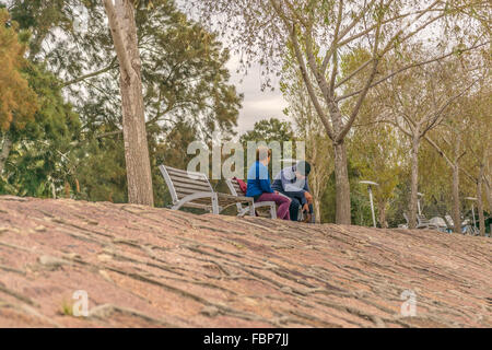 MONTEVIDEO, URUGUAY, Mai - 2015 - couple assis sur chaise en bois à la promenade de la côte de Santa Lucia river localiser Banque D'Images