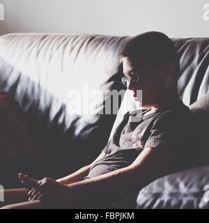 Boy Sitting on Sofa At Home