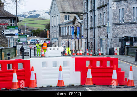 Storm Desmond a donné lieu à plus d'une trentaine de ponts détruits ou endommagés en Cumbria, perturbant les transports. Dans Kendal pont Victoria, qui avait été ouverte, est maintenant fermé à la circulation et les piétons après avoir découvert les plongeurs que les fondations sous ses jambes avaient été complètement minée. La fermeture a provoqué le chaos dans la circulation comme le pont de Kendal est le carrefour principal dans le nord de la ville sur la rivière Kent. Cette photo montre les travailleurs du Conseil mettant les obstacles jusqu'à arrêter tout passage à niveau. Photo prise le 14 janvier 2015. Banque D'Images