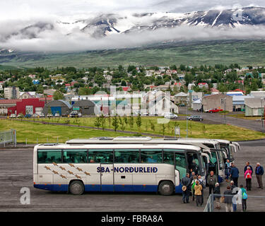 Akureyri, Islande, Islande. 1er août 2015. Les passagers des navires de croisière sélection autocars sur le dock dans le nord-est de port d'Akureyri, Islande, le deuxième plus grande zone urbaine dans le fjord Eyjafjordur. Entouré par le¡rdalur GlerÃ couvertes de neige montagnes couvertes de nuages de basse altitude, Akureyri est un important centre de pêche et le tourisme est devenu un secteur en pleine croissance de l'économie. © Arnold Drapkin/ZUMA/Alamy Fil Live News Banque D'Images