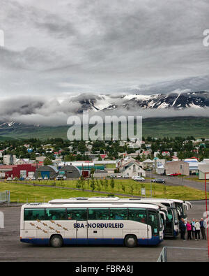 Akureyri, Islande, Islande. 1er août 2015. Les passagers des navires de croisière sélection autocars sur le dock dans le nord-est de port d'Akureyri, Islande, le deuxième plus grande zone urbaine dans le fjord Eyjafjordur. Entouré par le¡rdalur GlerÃ couvertes de neige montagnes couvertes de nuages de basse altitude, Akureyri est un important centre de pêche et le tourisme est devenu un secteur en pleine croissance de l'économie. © Arnold Drapkin/ZUMA/Alamy Fil Live News Banque D'Images