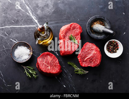 Frais crus de viande Steak marbré et les assaisonnements sur fond de marbre noir Banque D'Images