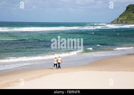 Couple walking Lennox Head et Seven Mile Beach sur la côte nord de la Nouvelle-Galles du Sud, Australie. Une destination de vacances populaire. Banque D'Images