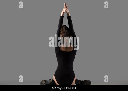 Belle jeune femme slim cool de faire du sport à la formation, des exercices d'étirement, le préchauffage, assis sur la variation des Gomukhasana Banque D'Images