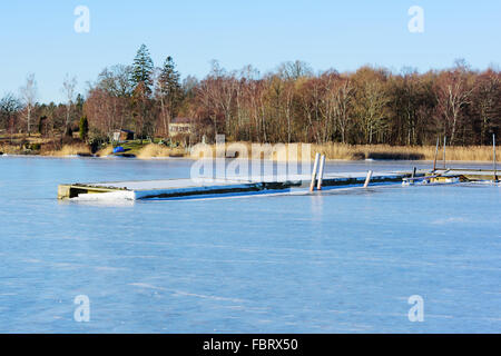 Paysage d'hiver paysage marin avec pont flottant ou gelés dans la glace de mer. Couvrir le gel pier. Listerby, Suède. Banque D'Images