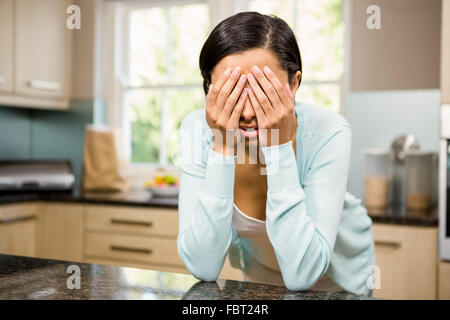 Triste brunette avec les mains sur son visage Banque D'Images