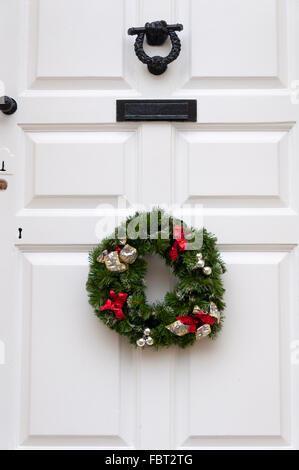 Couronne de Noël blanc sur la pendaison de porte avant Banque D'Images